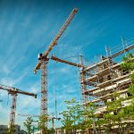 Construction site in the blazing sun with greenery around